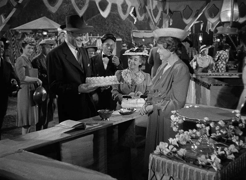 Stehphen guesses the weight of a cake at a night-time fete