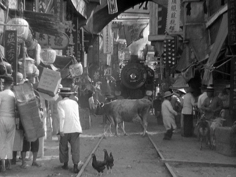 The train makes its way down a market street