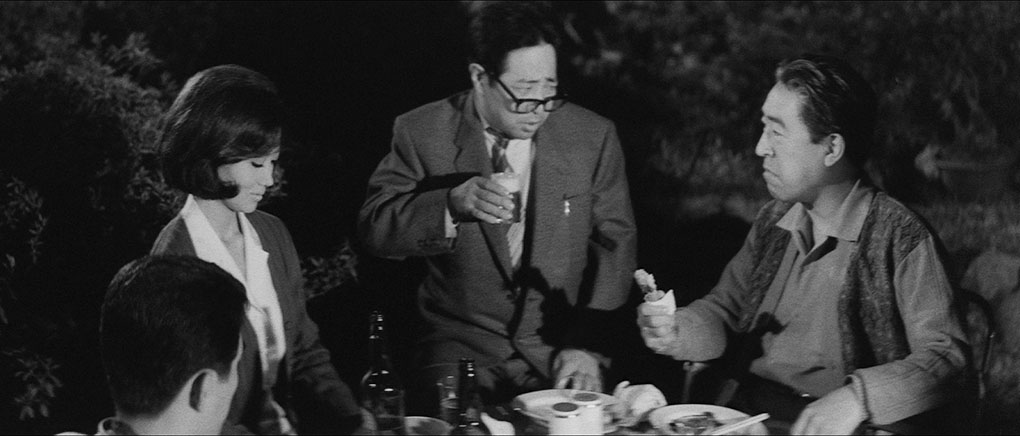 A drunken Yamazaki coinverses with Denzo at a garden partry as Yumiko and Shizuo listen