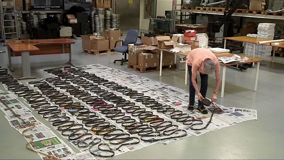 Erlendur Sveinsson carefully unspools the recovered film on the archive floor